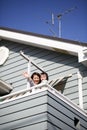 Japanese mother and child waving hands on the veranda at home